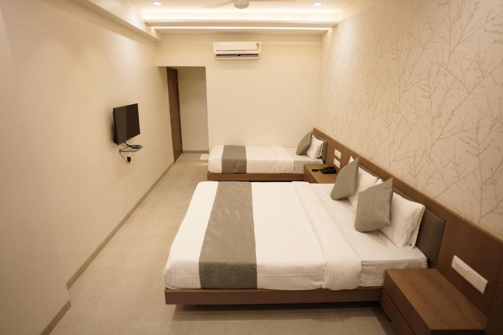 Postel nebo postele na pokoji v ubytování A Square Executive Hotel