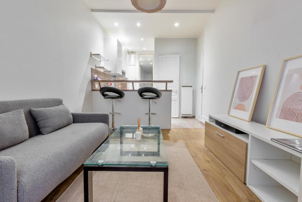 un salon avec un canapé et une table dans l'établissement Marché Ordener - Appartement refait à neuf proche Montmartre, à Paris