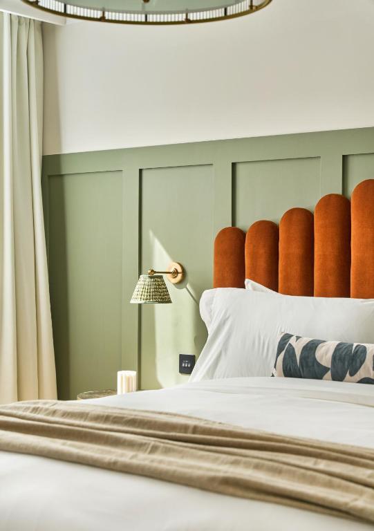 a bedroom with a bed with a headboard and a lamp at The Store in Oxford