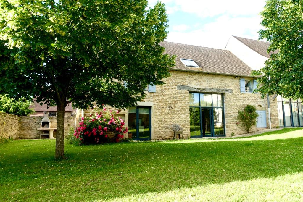 une maison en briques avec un arbre dans la cour dans l'établissement Havre de paix en bourgogne, à Saint-Clément-sur-Guye