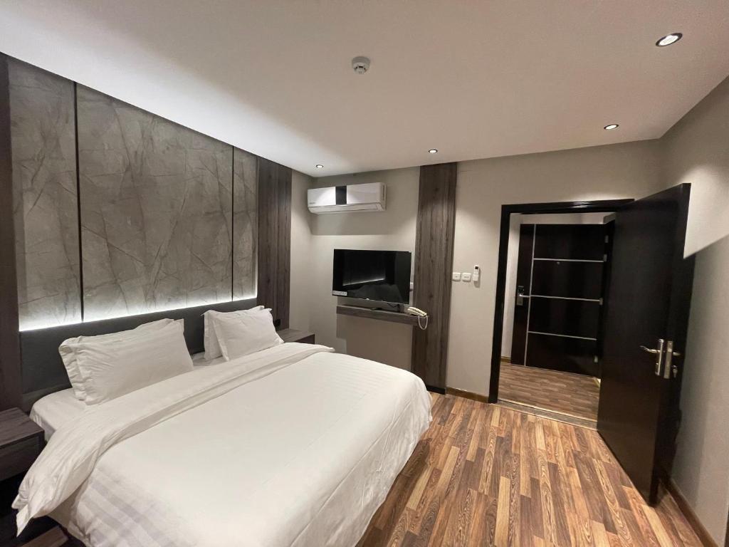 a bedroom with a large white bed and a television at شقق درر رامه للشقق المخدومة 2 in Riyadh