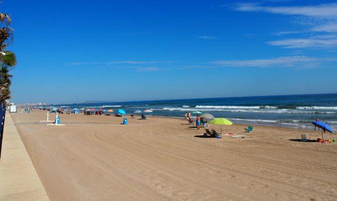 a group of people on a beach with umbrellas at TARONGERS MIRAMAR PLAYA - Alquiler solo a Familias in Miramar