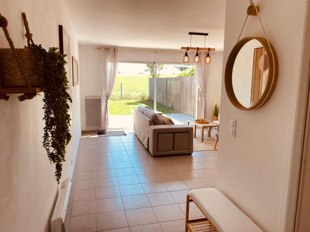 a living room with a couch and a mirror at Maison moderne avec jardin in Saint-Xandre