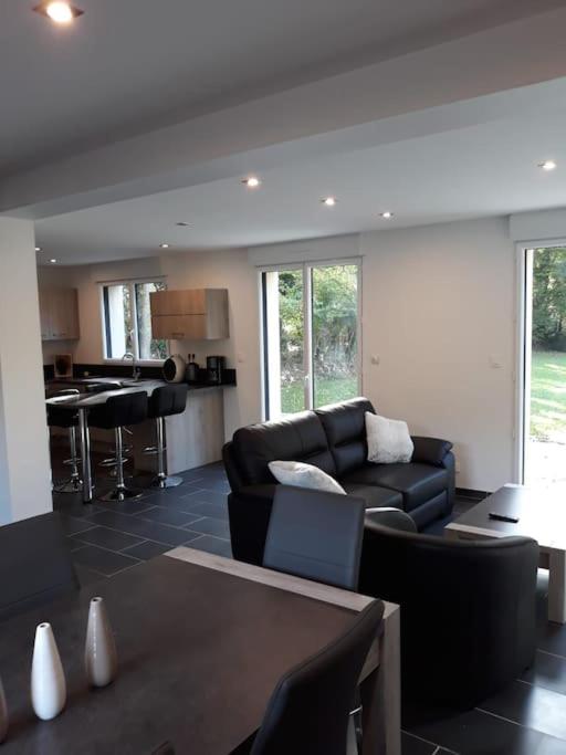 un salon avec un canapé et une table dans l'établissement Charmante maison, proche de DEAUVILLE, à Saint-Étienne-la-Thillaye