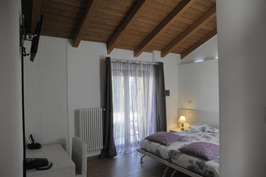 1 dormitorio con cama y ventana grande en Al Castello Bed and Breakfast, en Cornate dʼAdda