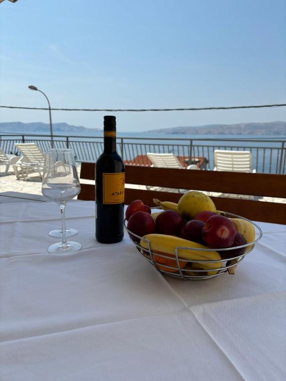 een fles wijn en een fruitschaal op een tafel bij Apartment Sanja in Senj