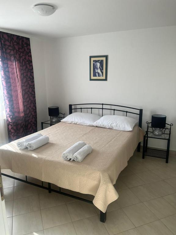 a bedroom with a large bed with two towels on it at Apartment Tihana in Cres
