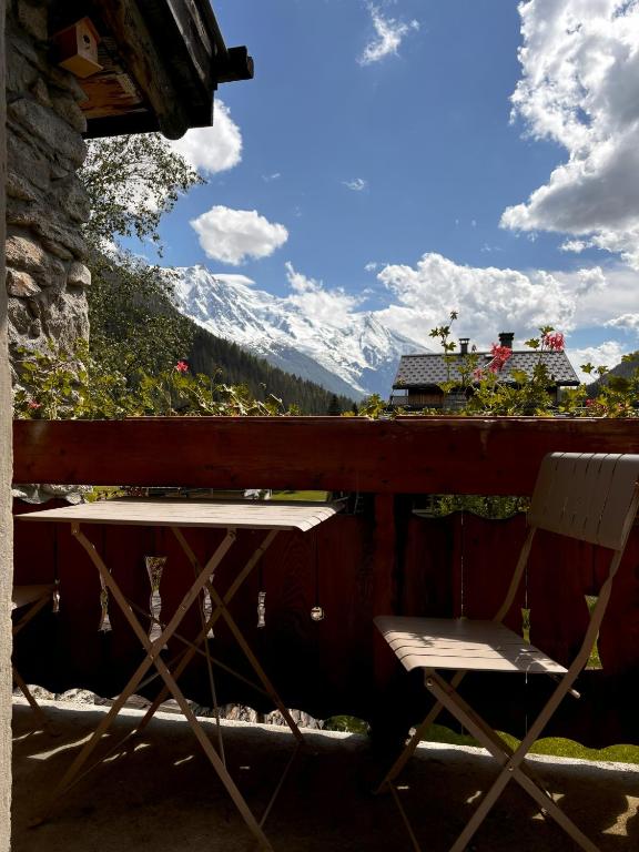 d'une table et de chaises sur un balcon avec une montagne enneigée. dans l'établissement Appartement Chamonix, à Chamonix-Mont-Blanc