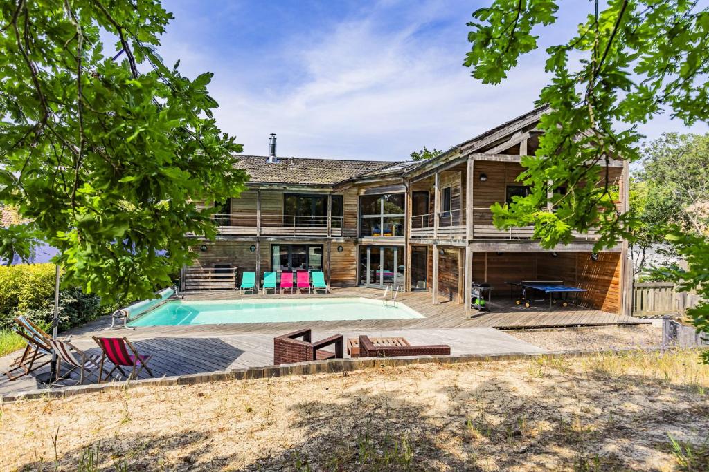une vue extérieure d'une maison avec piscine dans l'établissement Villa 5ch au calme dans le domaine du golf, à Lacanau