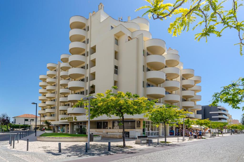 un grande edificio bianco con alberi di fronte di TURIM Algarve Mor Apartamentos Turísticos a Portimão