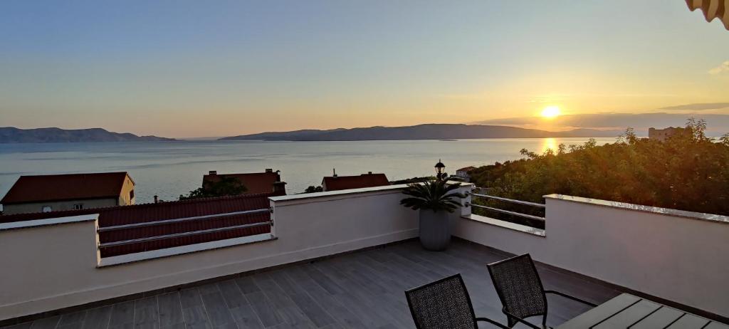 a balcony with a view of the ocean at sunset at Apartments Tatjana in Senj
