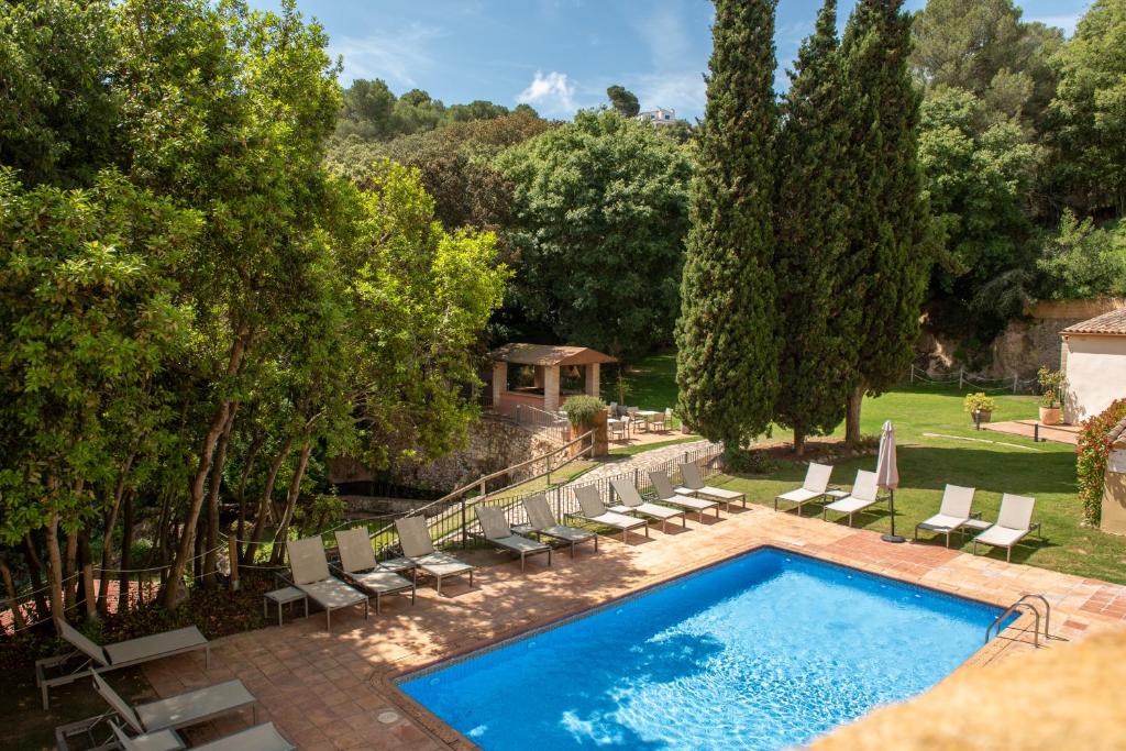 an outdoor swimming pool with chairs at Hotel Convent de Begur in Begur
