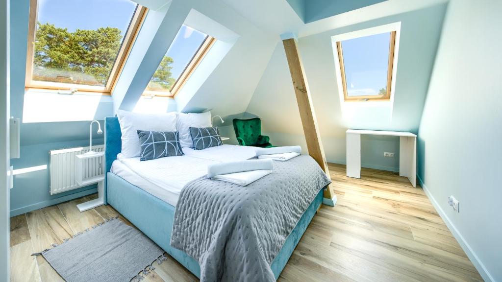 una camera da letto con un letto con pareti e finestre blu di Las i Morze, Sun & Snow a Mrzeżyno