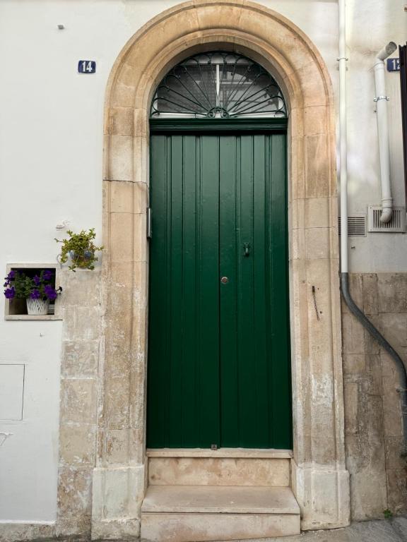 a green door in a building with an arch at Nonna Gio' in Martina Franca