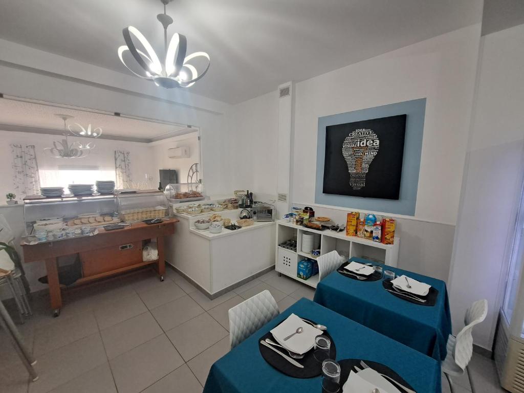 a room with two tables and a kitchen with a counter at Maniel Beach Hotel in Letojanni