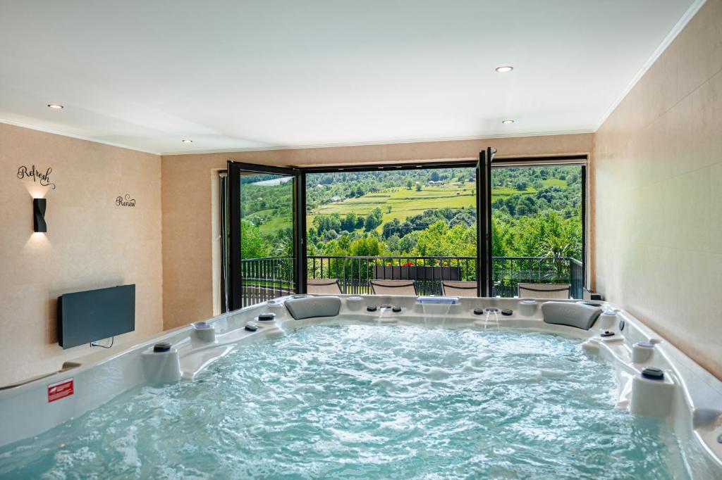 a jacuzzi tub in a room with a view at Country Relax Resort in Săcuieu
