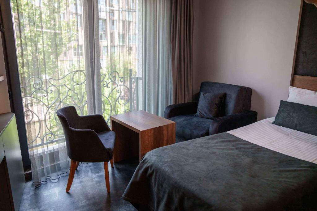 Postel nebo postele na pokoji v ubytování SennaCity Hotel