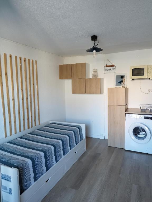 Cette petite chambre comprend un lit et un lave-linge. dans l'établissement Studio cabine, à Saint-Cyprien