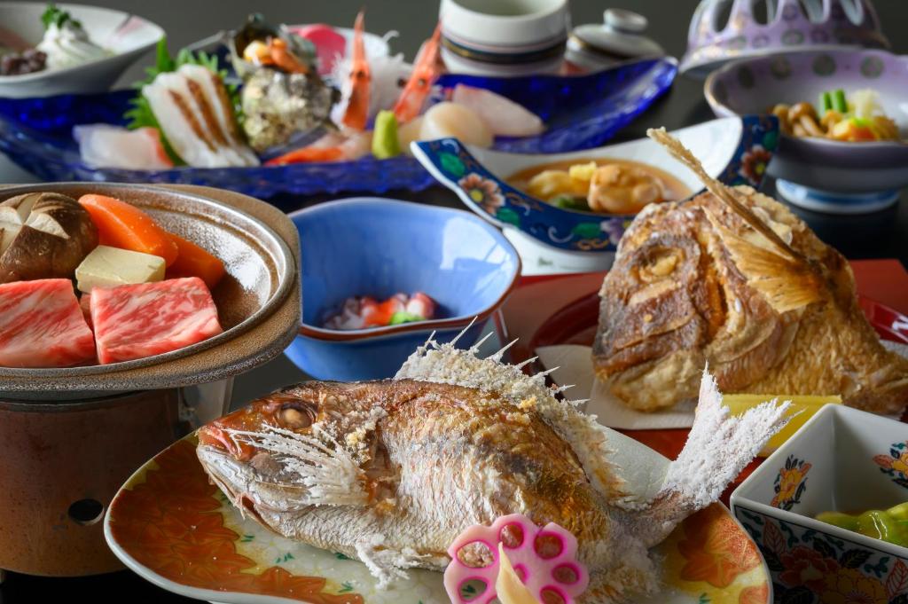 鶴岡市にある竹屋ホテルの皿の上に魚が乗った食べ物がいっぱいのテーブル