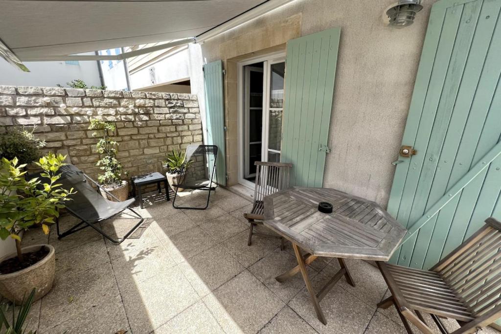eine Terrasse mit Stühlen und einem Tisch auf einem Haus in der Unterkunft Chauveau - entre port et plage in Saint-Martin-de-Ré