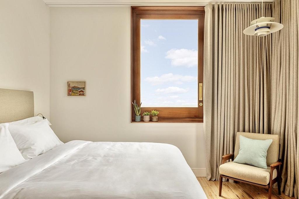 a bedroom with a bed and a window and a chair at Fort Road Hotel in Margate