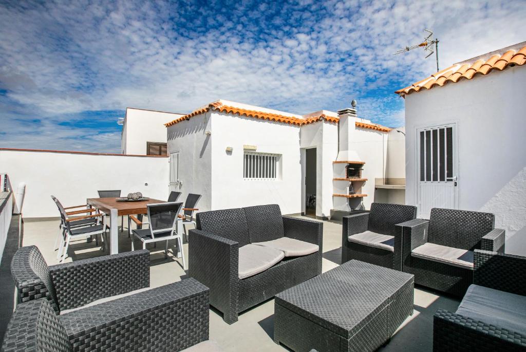a patio with wicker chairs and a table at Casa Rural Bodega Oramas in Arico