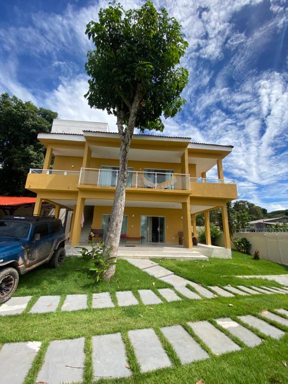 a yellow house with a tree in front of it at Casa Amarilla Alter in Alter do Chao