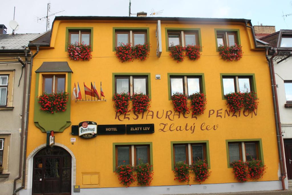 a yellow building with flower boxes on it at Zlatý lev in Svitavy