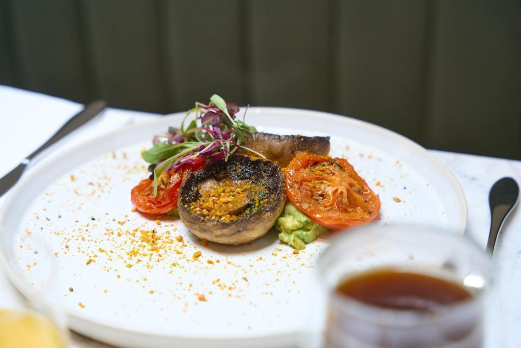 a plate of food with tomatoes and meat on a table at The Store in Oxford
