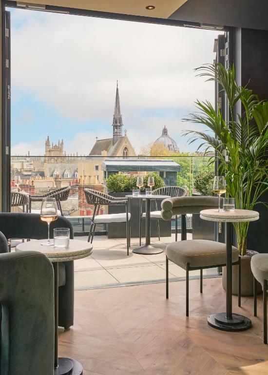 a restaurant with tables and chairs and a view of the city at The Store in Oxford
