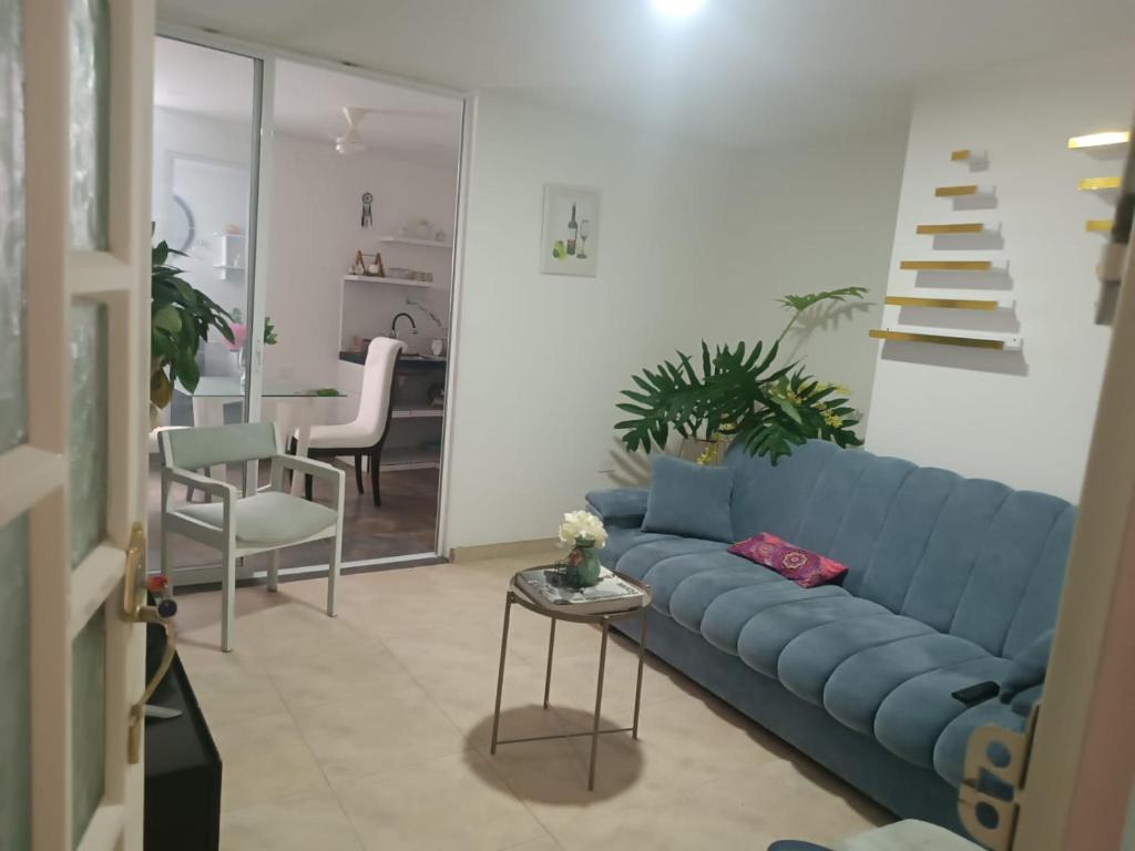ein Wohnzimmer mit einem blauen Sofa und einer Treppe in der Unterkunft Apartahotel Acuña in Moniquirá