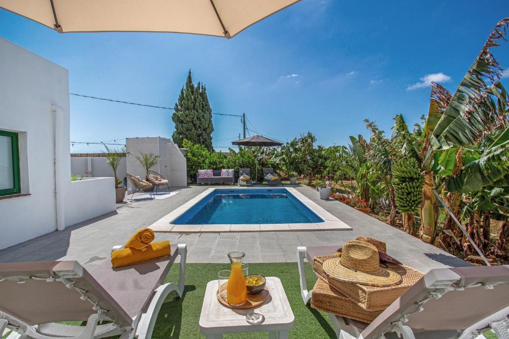 Un patio trasero con piscina, mesa y sillas. en Piscina Climatizada, en La Hidalga