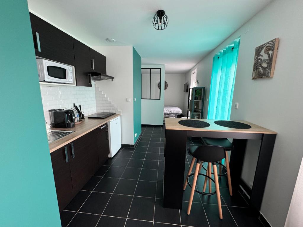 a kitchen with a counter and a kitchen with a sink at Appartement avec terrasse privée in Chaumont