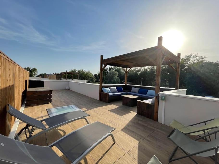un toit-terrasse avec des chaises et un kiosque dans l'établissement Belle villa climatisee 6 pers proche plage solarium piscine - V0755, à Vias