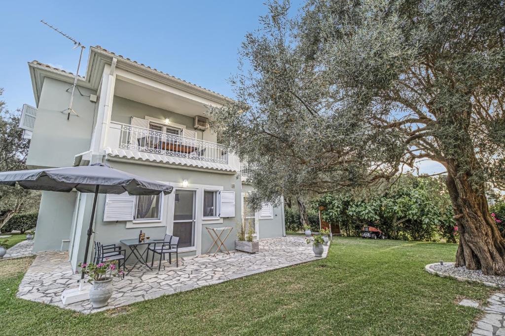 een huis met een patio en een parasol bij Elaia studio 5 in Lefkada