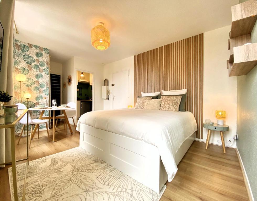 - une chambre avec un lit blanc et une salle à manger dans l'établissement Le Bohème Tourisme Repos Business à Toulouse, à Toulouse