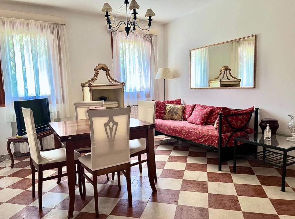 a living room with a red couch and a table at Venice Secret Garden view in Venice