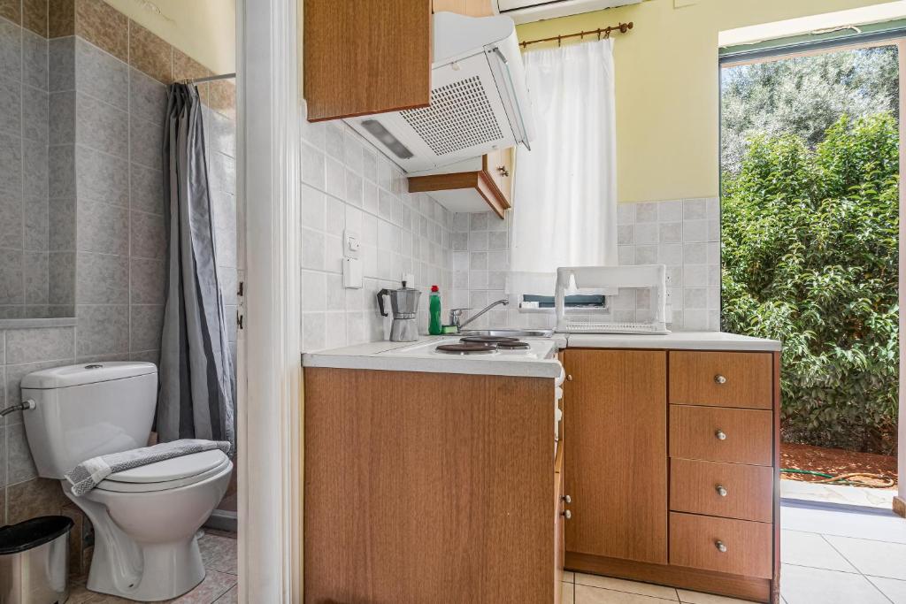 łazienka z umywalką, toaletą i oknem w obiekcie Ionian Breeze Studio 3 w mieście Leukada (miasto)