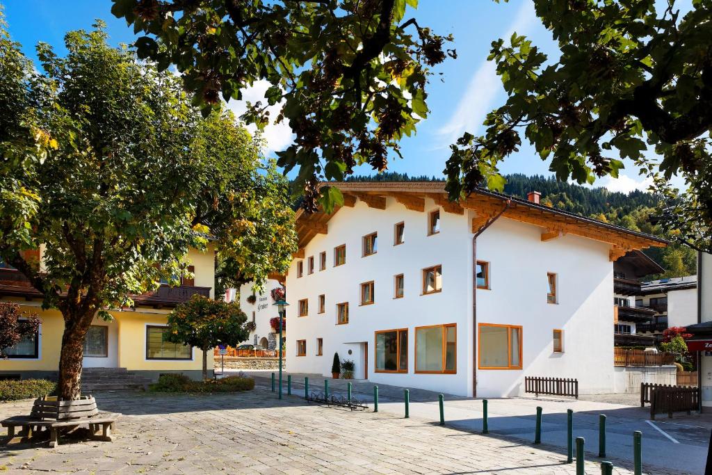 a white building with a tree in front of it at Appartement Haus Sonne in Zell am See
