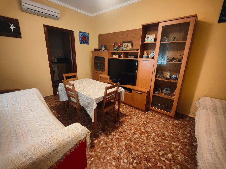 a room with a table and chairs and a tv at Apartamento corrales in Chipiona