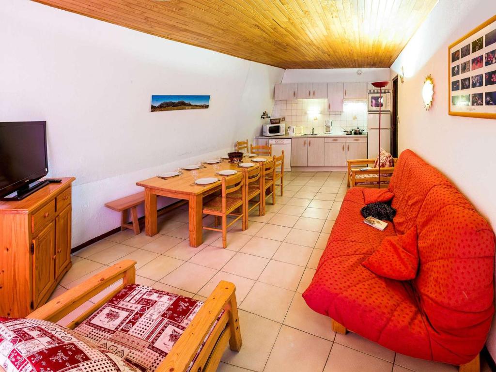 un salon avec un canapé rouge et une table dans l'établissement Grand appartement pour 12 pers. avec balcon sud, WIFI, parking et proche pistes – St Michel de Chaillol - FR-1-393-11, à Saint-Michel-de-Chaillol