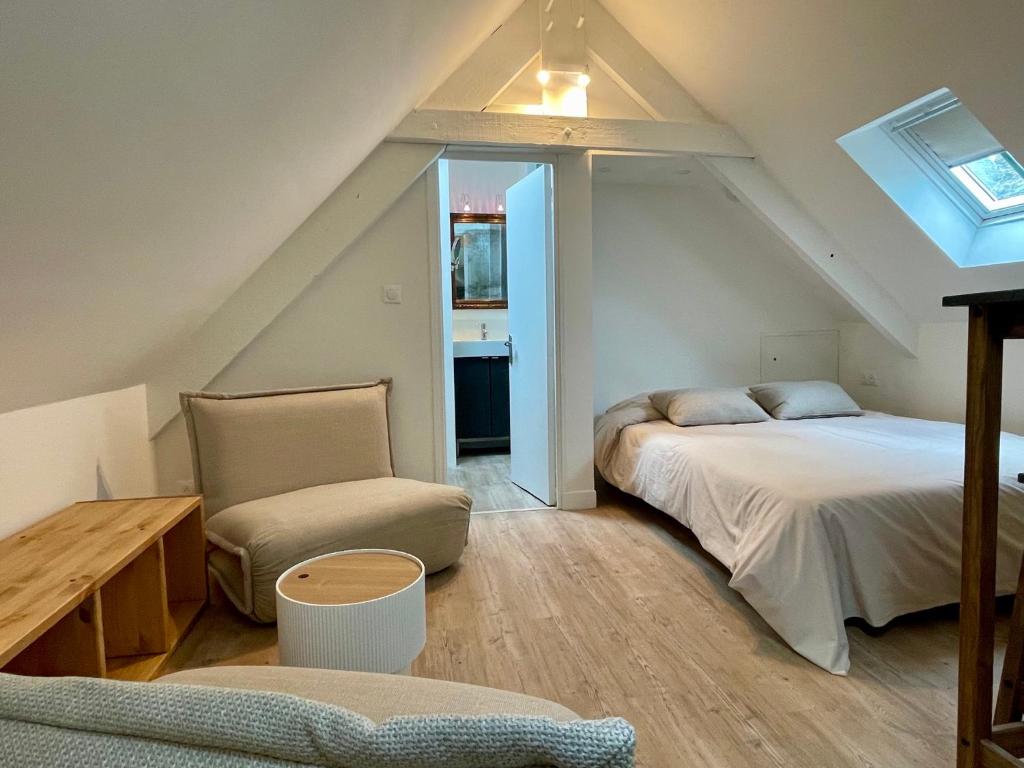 - une chambre mansardée avec 2 lits et une chaise dans l'établissement Ker Latitude 3 vieux Dinan, à Dinan