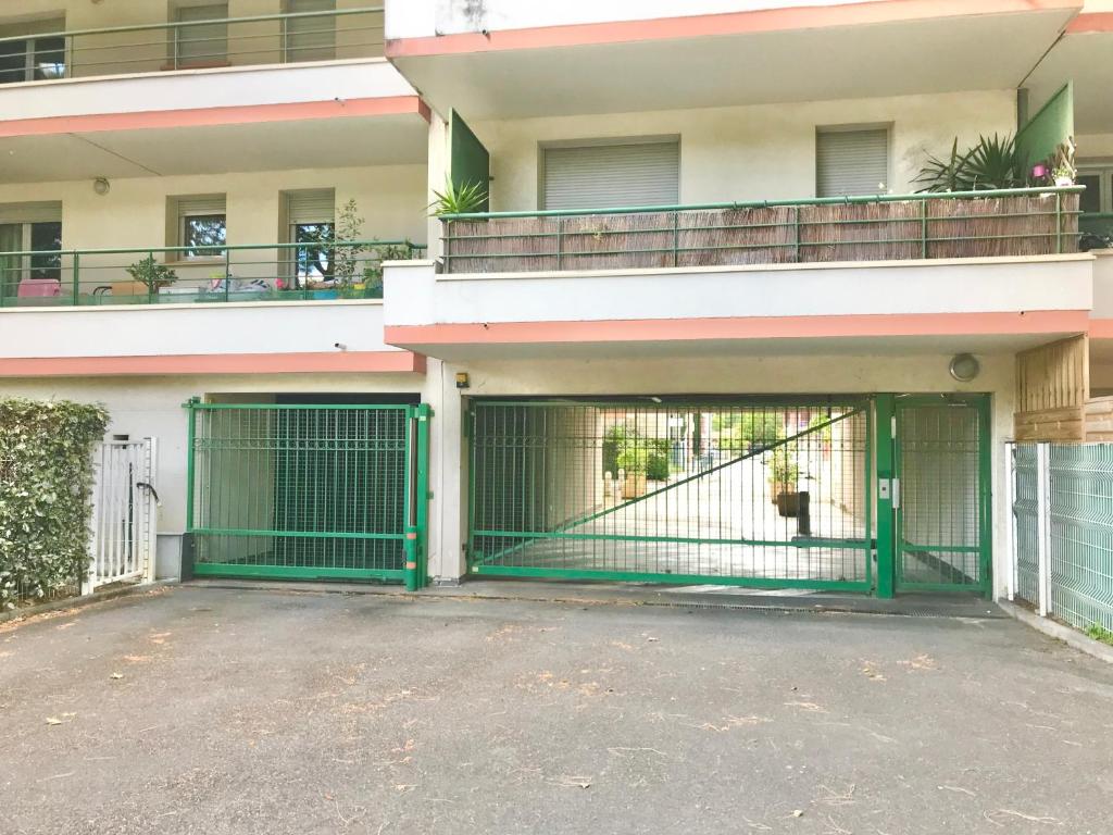 a building with a green gate in front of it at La PASSERELLE in Toulouse
