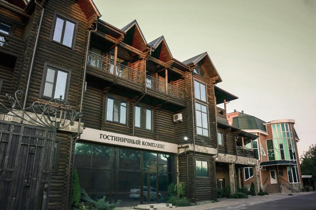 a large wooden building with a sign in front of it at Villa Club in Armavir