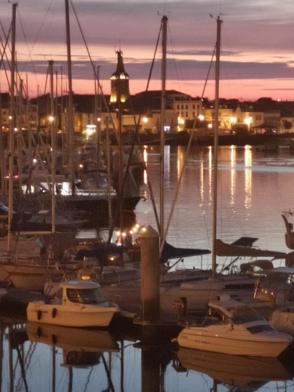 un groupe de bateaux amarrés dans une marina la nuit dans l'établissement En mansarde sur le port, à Les Sables-dʼOlonne