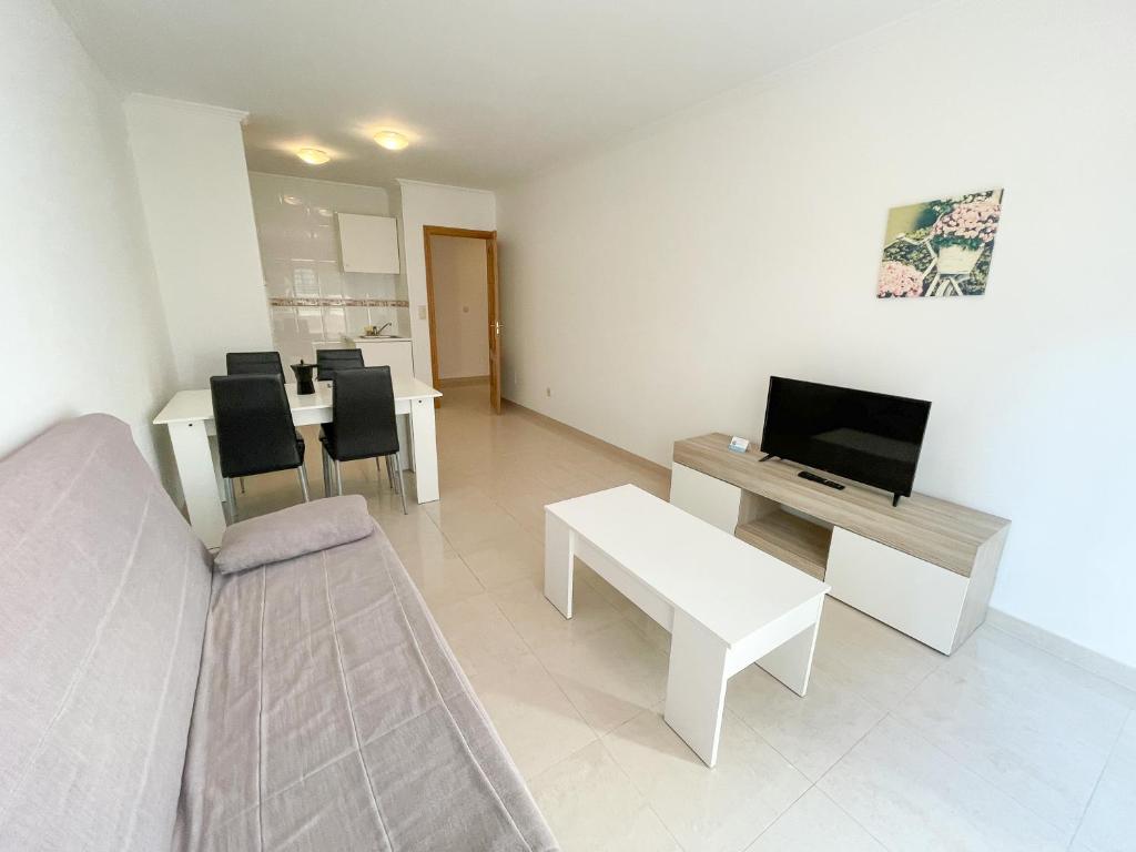 Televízia a/alebo spoločenská miestnosť v ubytovaní Apartamentos Playa de la Lanzada 3000
