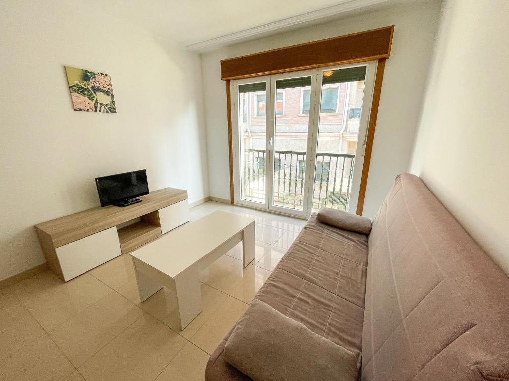 Televízia a/alebo spoločenská miestnosť v ubytovaní Apartamentos Playa de la Lanzada 3000