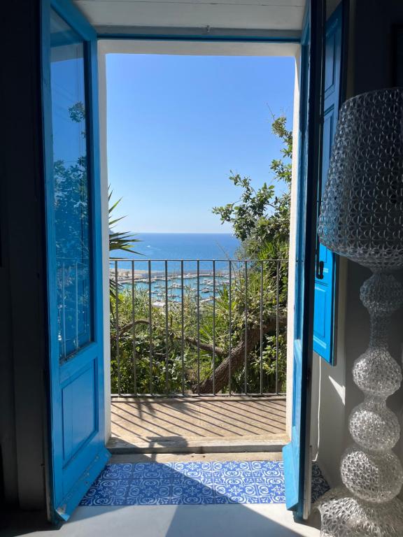 an open door to a balcony with a view of the ocean at La Casa del Nespolo - Exclusive Country Suites - Seaview Pool & Self Check-in in Capo dʼOrlando