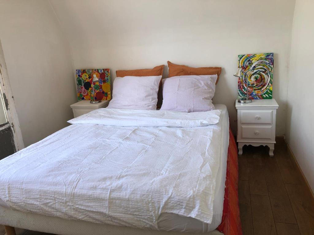 une chambre avec un lit blanc avec deux tables de nuit dans l'établissement Romantic, à Paris
