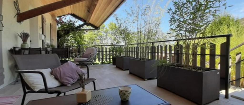 un patio avec des chaises et une table sur un balcon dans l'établissement PetiteViolette, à Annecy
